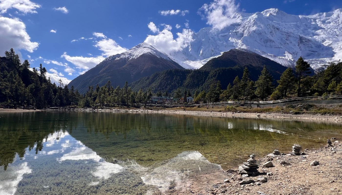 Gangapurna Lake near Manang village reflecting Annapurna III and Gangapurna mountains on a clear day along the Annapurna Circuit Trek.