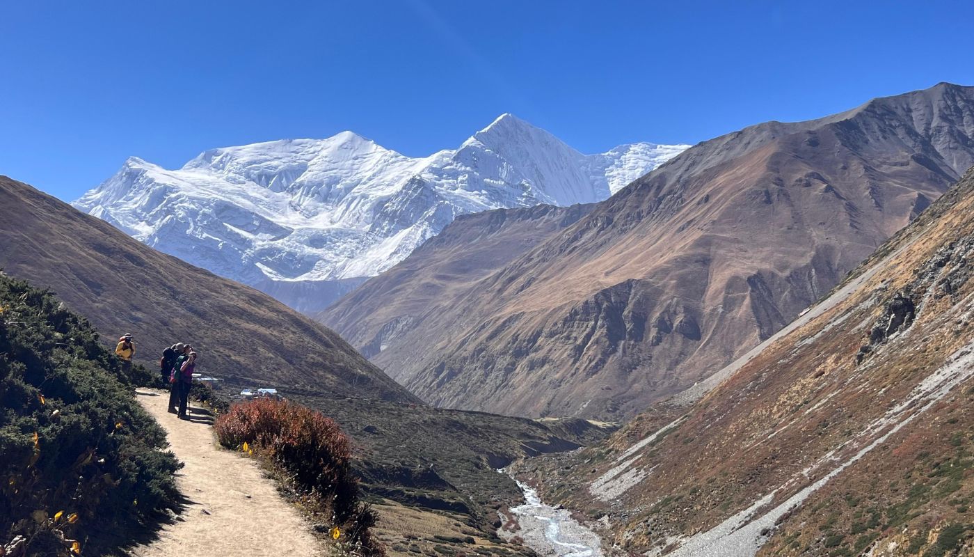 Trekkers walking towards Thorong Phedi and High Camp with Annapurna III and Gangapurna Himal in the background, Annapurna Circuit Trek, Nepal.